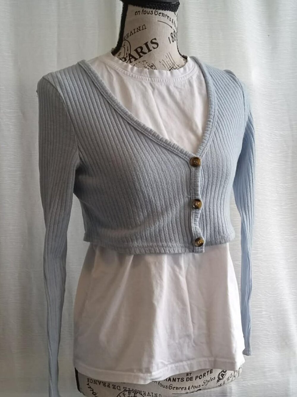 Short powder blue cardigan with three buttons in a ballerina style